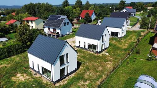 Nowe domy w sąsiedztwie terenów zielonych / Ujazd