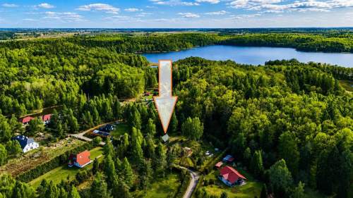 Domek nad jeziorem w otoczeniu lasów 