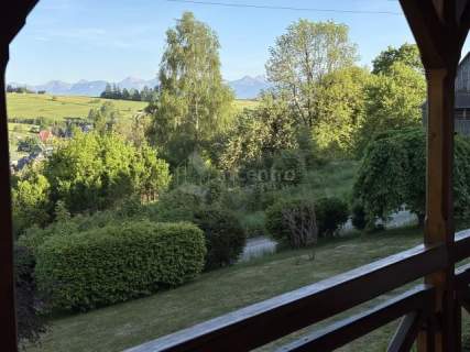 Góralski drewniany dom z widokiem na Tatry