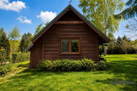 Domek nad jeziorem w otoczeniu lasów 