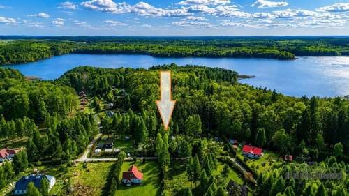Domek nad jeziorem w otoczeniu lasów 