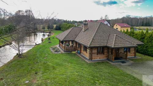 Dom z pełnego bala z zarybionym stawem