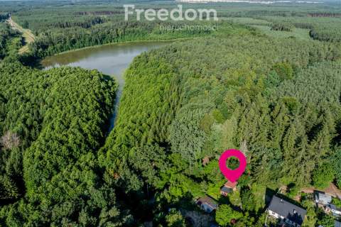 Działka w lesie blisko jeziora z budynkami