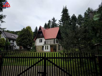 Dom przy strumyku w otoczeniu zieleni